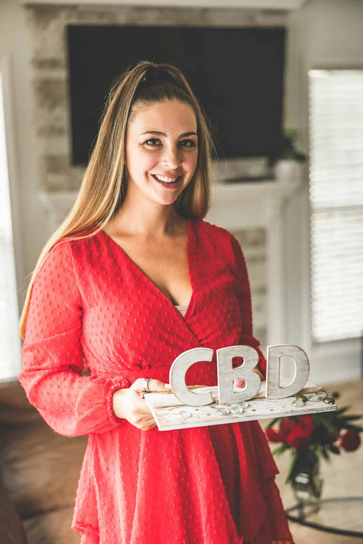 A picture of Emily Kyle holding a CBD sign.